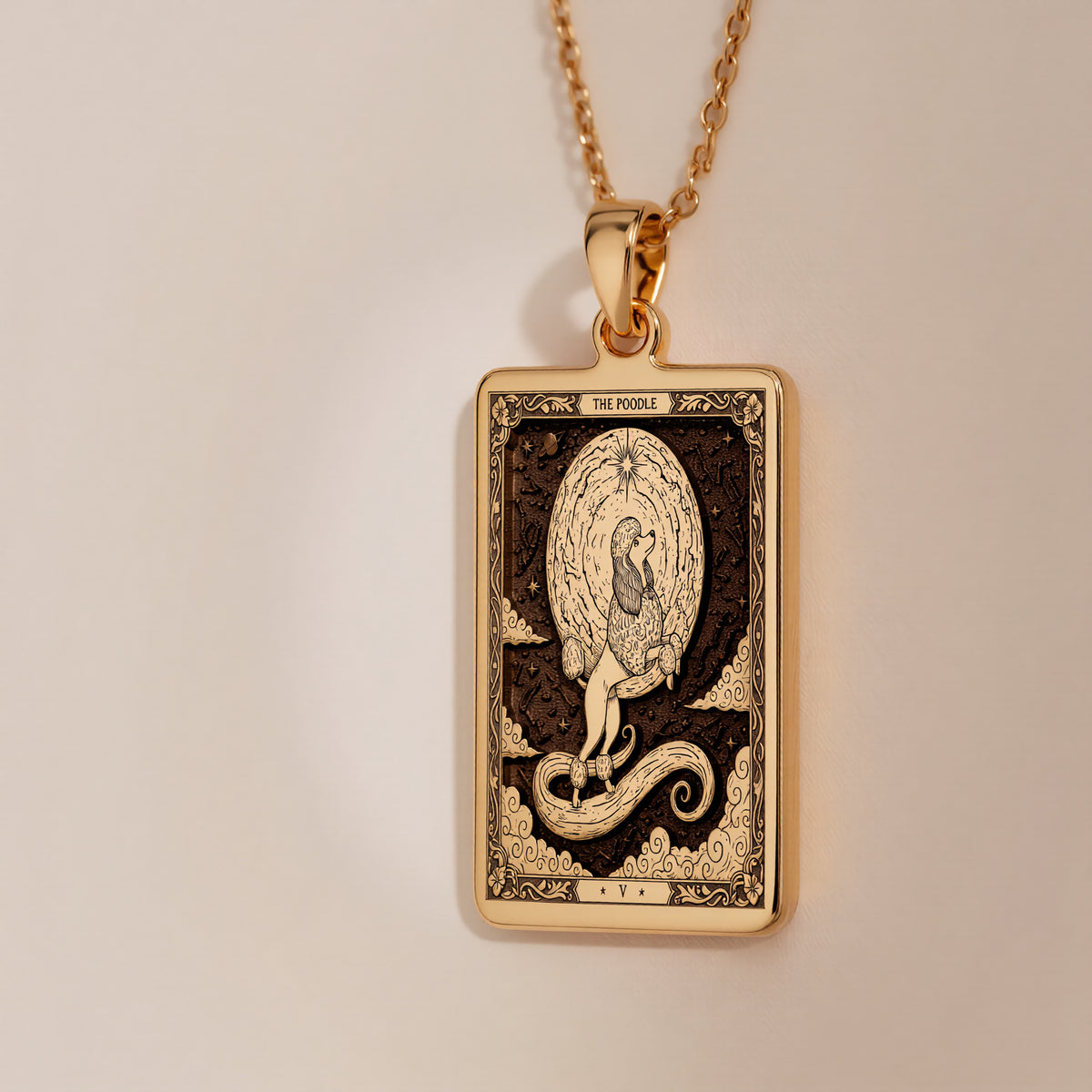 A gold-colored pendant necklace with a rectangular pendant featuring a tarot card design, surrounded by various natural elements such as rocks, flowers, and moss.