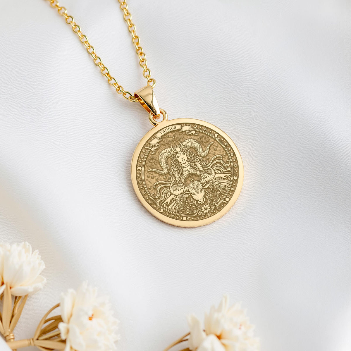 A polished 14K solid gold Taurus pendant. This fine astrology jewelry represents the earth sign's loyalty, making it a perfect gift for her.