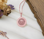 a pink necklace with a flower on it