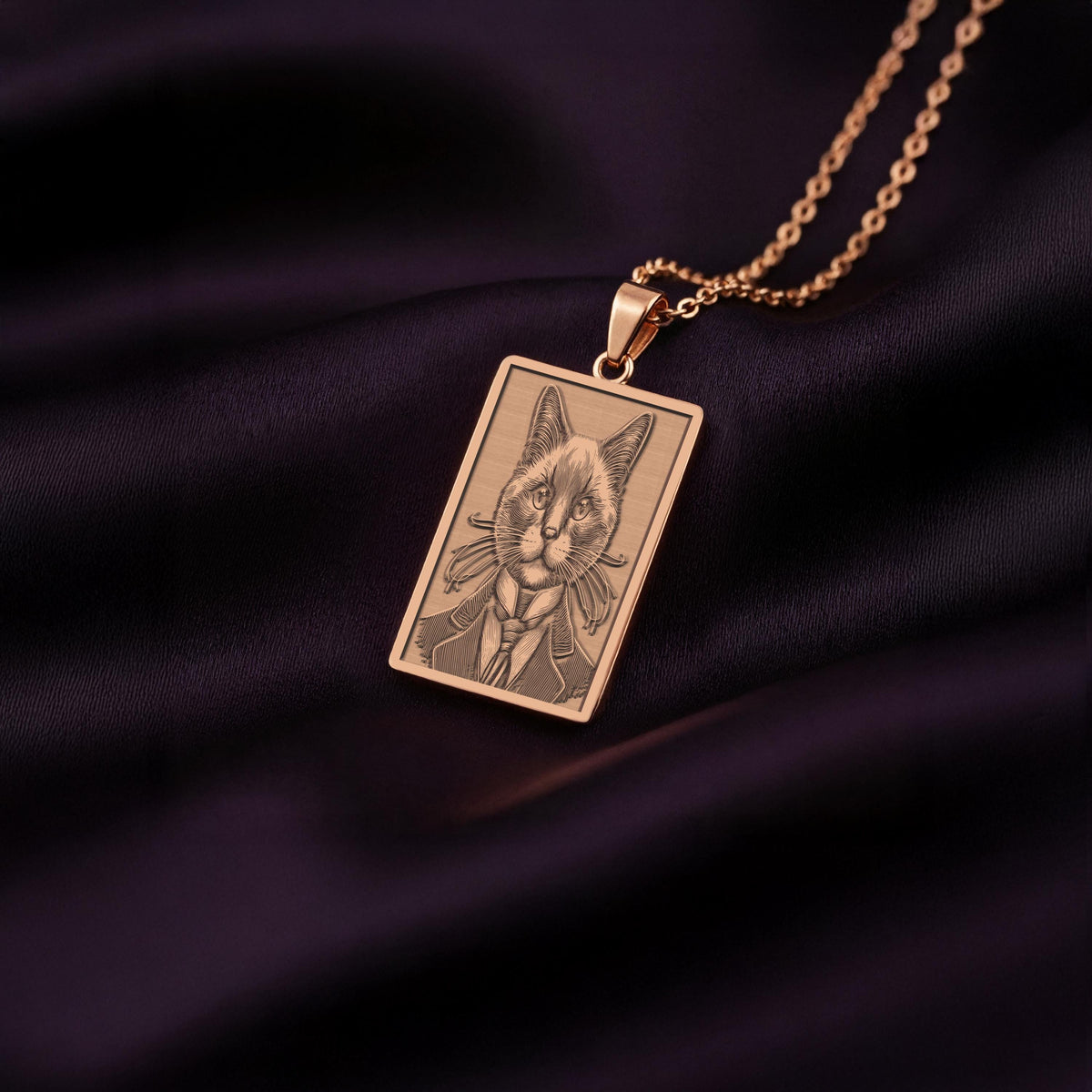 A stylish rose gold plated necklace with a rectangular pendant, featuring a unique engraved portrait of a sophisticated Siamese cat.