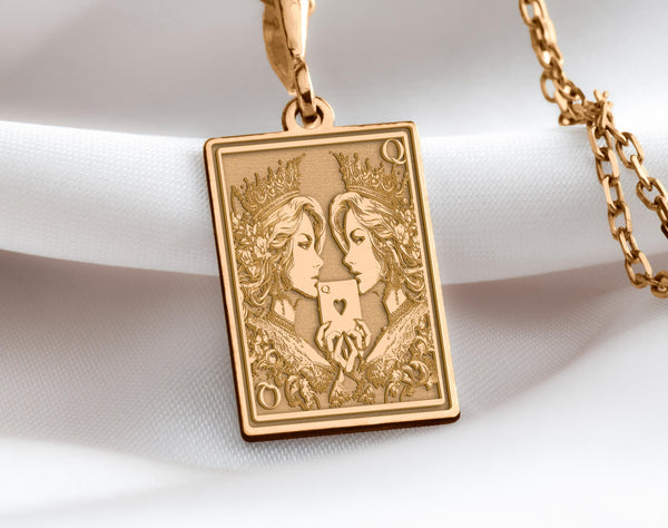 Gold Ace of Queens pendant featuring two intricately detailed queens holding a heart card, symbolizing sapphic love, LGBTQ+ pride, and empowerment.