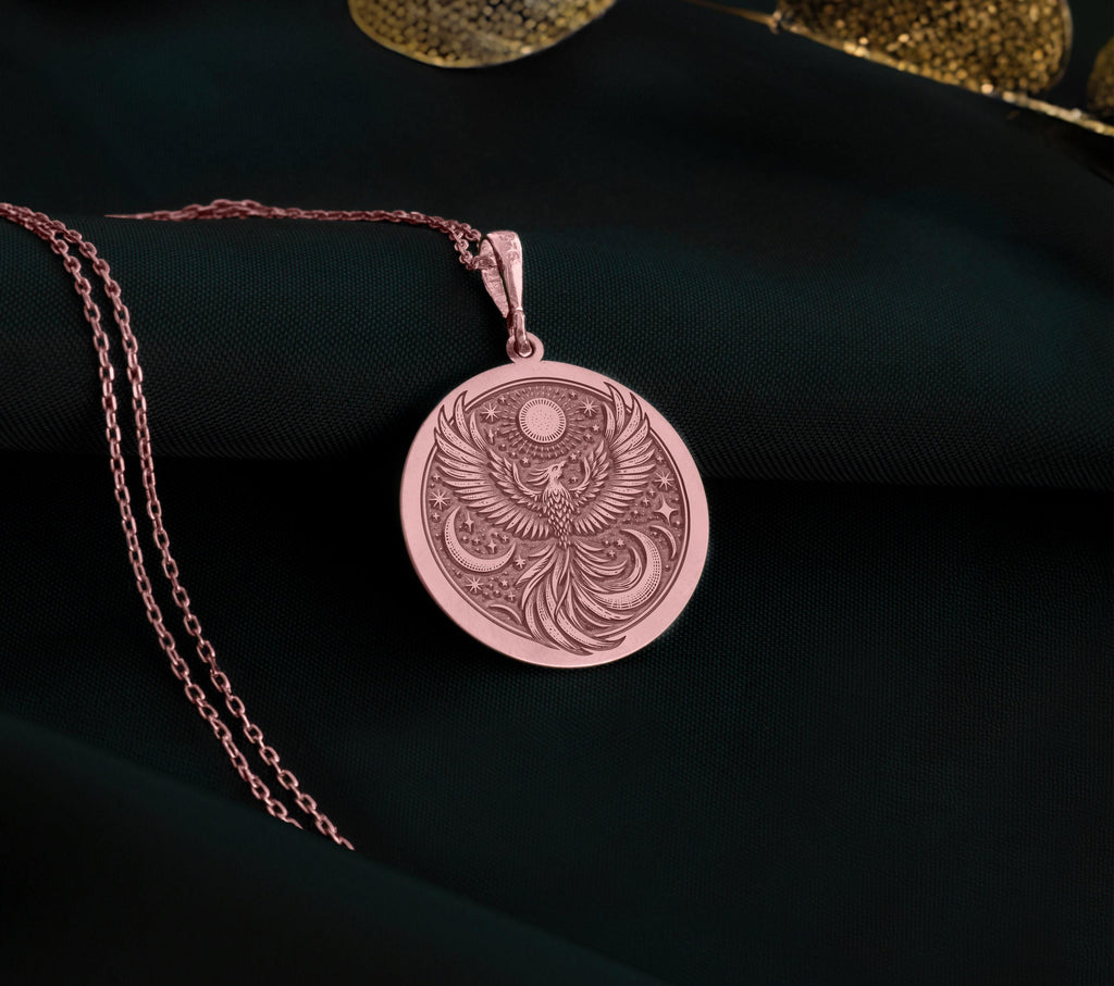 Firebird Mythical Phoenix Pendant Necklaces Rose 14K Rose 14K 14K Rose 14K 14K Rose Gold Plated circular pendant necklace with ornate bird design on dark fabric.
