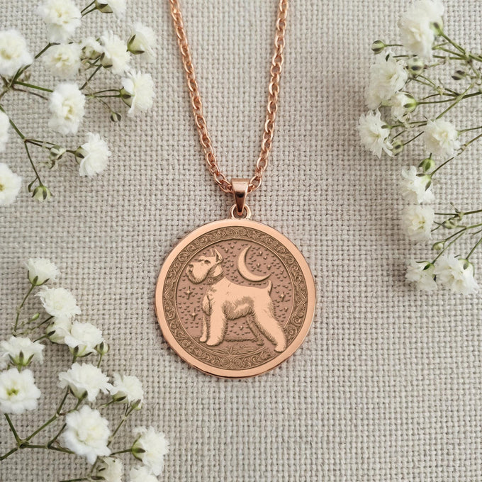 Rose Gold Plated Schnauzer medallion with a warm, pinkish hue. The pendant features a detailed engraving of the classic Schnauzer silhouette inside an ornate, patterned border. Elegant and meaningful dog breed jewelry for a beloved pet owner.