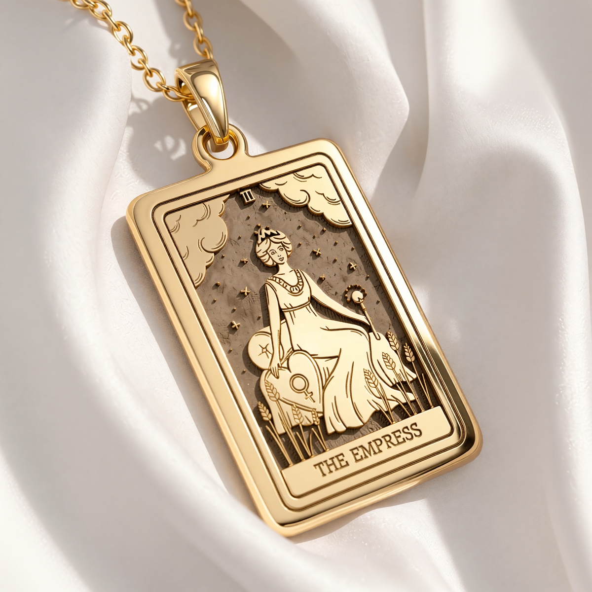 Empress Tarot Necklace pendant in gold plated finish. Rectangular design shows seated Empress with wheat, clouds and stars.