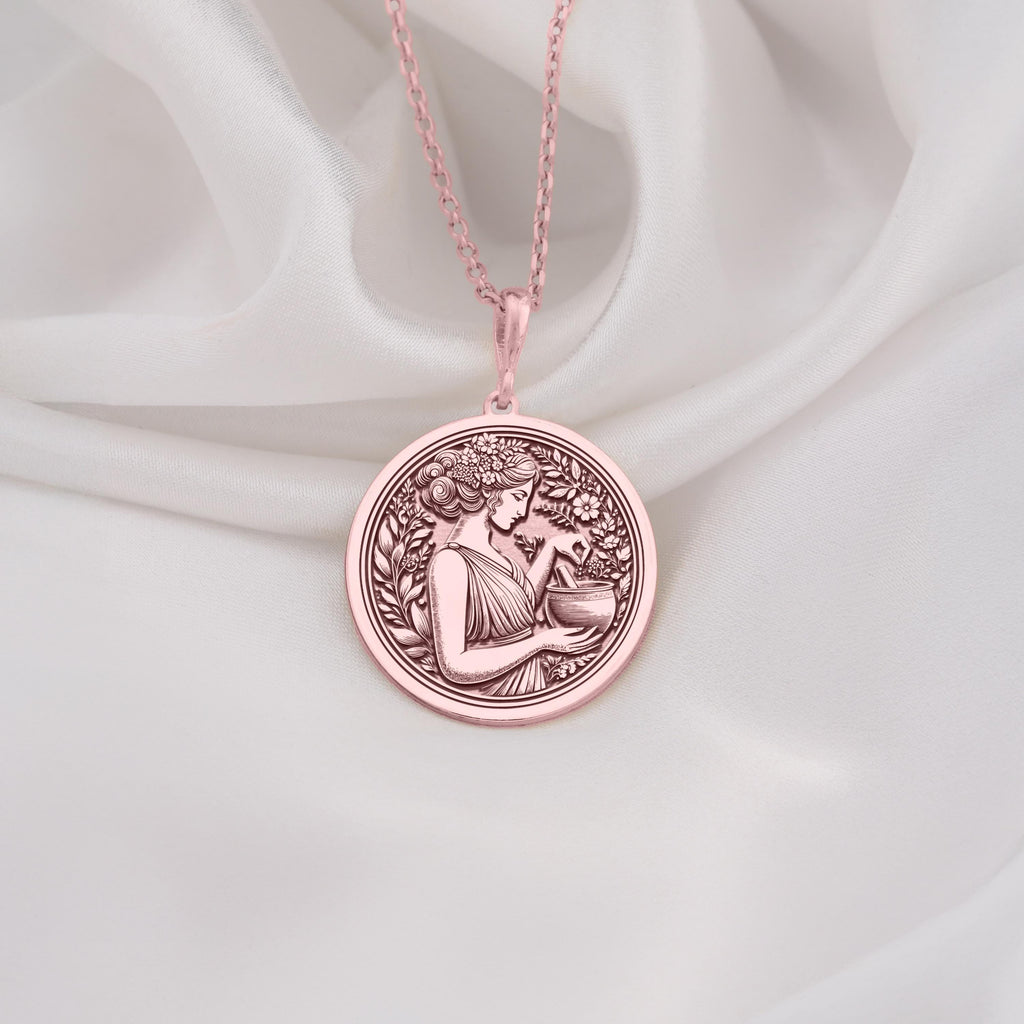 Rose Gold Plated Panacea Medallion featuring Greek healing goddess with medicinal vessel. Elegant wellness jewelry with intricate floral wreath border. Warm-toned mythology coin pendant, perfect meaningful gift for medical field.