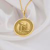 14K solid gold Buddha pendant necklace featuring a detailed medallion of Buddha in resting pose. This circular pendant showcases Buddha with head resting on hand in peaceful meditation, with intricate relief engravings and ornate border design. The pendant has an antique finish highlighting the serene details and hangs from a delicate gold chain against white silk fabric. This premium 14K gold spiritual jewelry piece represents peace, enlightenment,