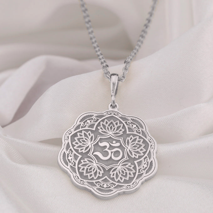 Silver pendant necklace featuring a detailed lotus flower design with intricate filigree details and a smooth surface finish. The pendant hangs from a delicate chain, viewed from the front.