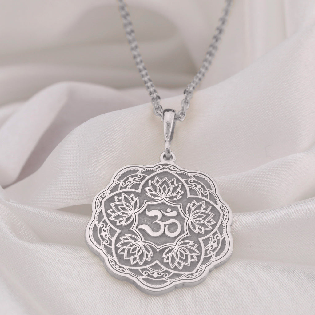 Silver pendant necklace featuring a detailed lotus flower design with intricate filigree details and a smooth surface finish. The pendant hangs from a delicate chain, viewed from the front.