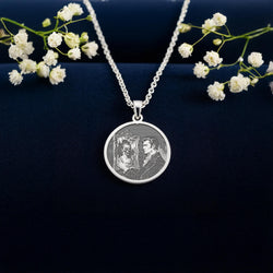 Dorian Gray Portrait Pendant: sterling silver round pendant with engraved portrait and reflection in ornate mirror, front view.