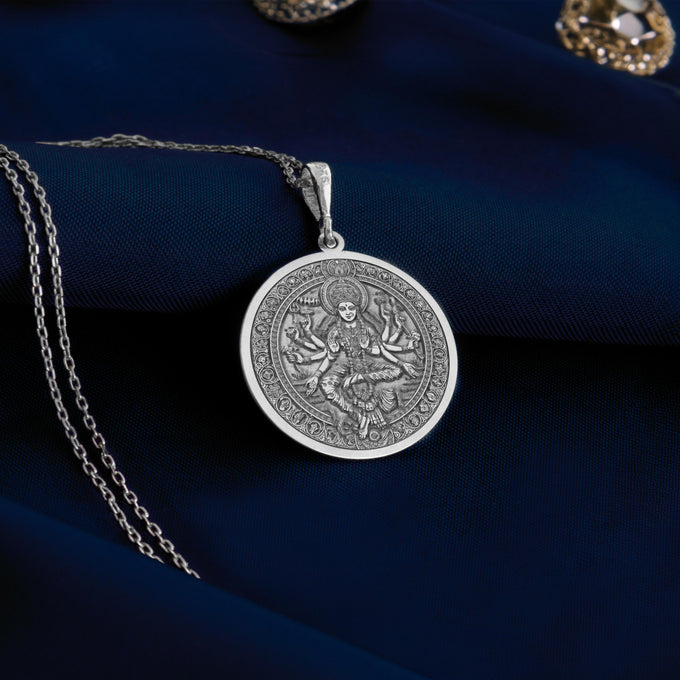 Silver pendant necklace featuring an intricate design of the Shri Lalita Goddess, circular shape with detailed mythological motifs. The pendant has a textured surface finish and is suspended from a silver chain.