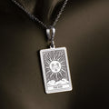 Silver pendant featuring a rectangular design of the Sun Tarot Major Arcana card with radiating sun rays and a stylized sun motif. The pendant has a polished finish and is attached to a silver chain.