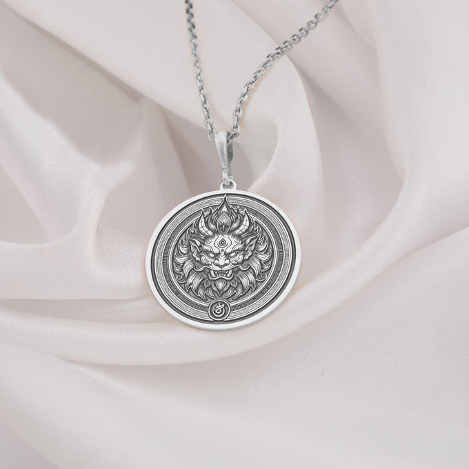Silver circular pendant featuring an intricately detailed lion face with a crown design. This piece has a polished surface and hangs from a silver-toned chain.