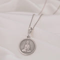 Buddha Medallion Necklace: Sterling silver pendant with engraved seated Buddha silhouette for spiritual protection.