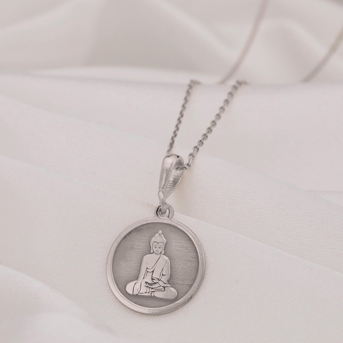 Buddha Medallion Necklace: Sterling silver pendant with engraved seated Buddha silhouette for spiritual protection.