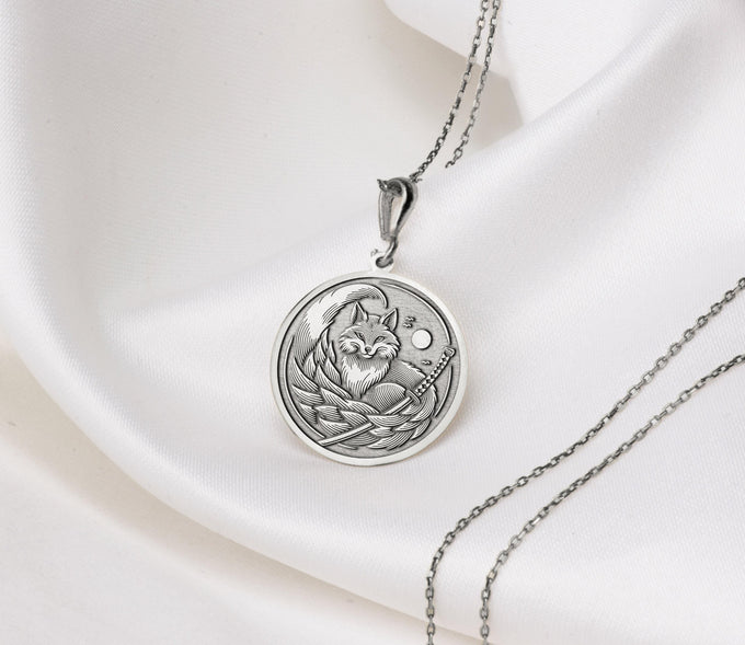 Silver plated circular pendant featuring an intricate design of a fox with flowing lines and a background circle. The pendant is attached to a silver chain and displayed against a white background.