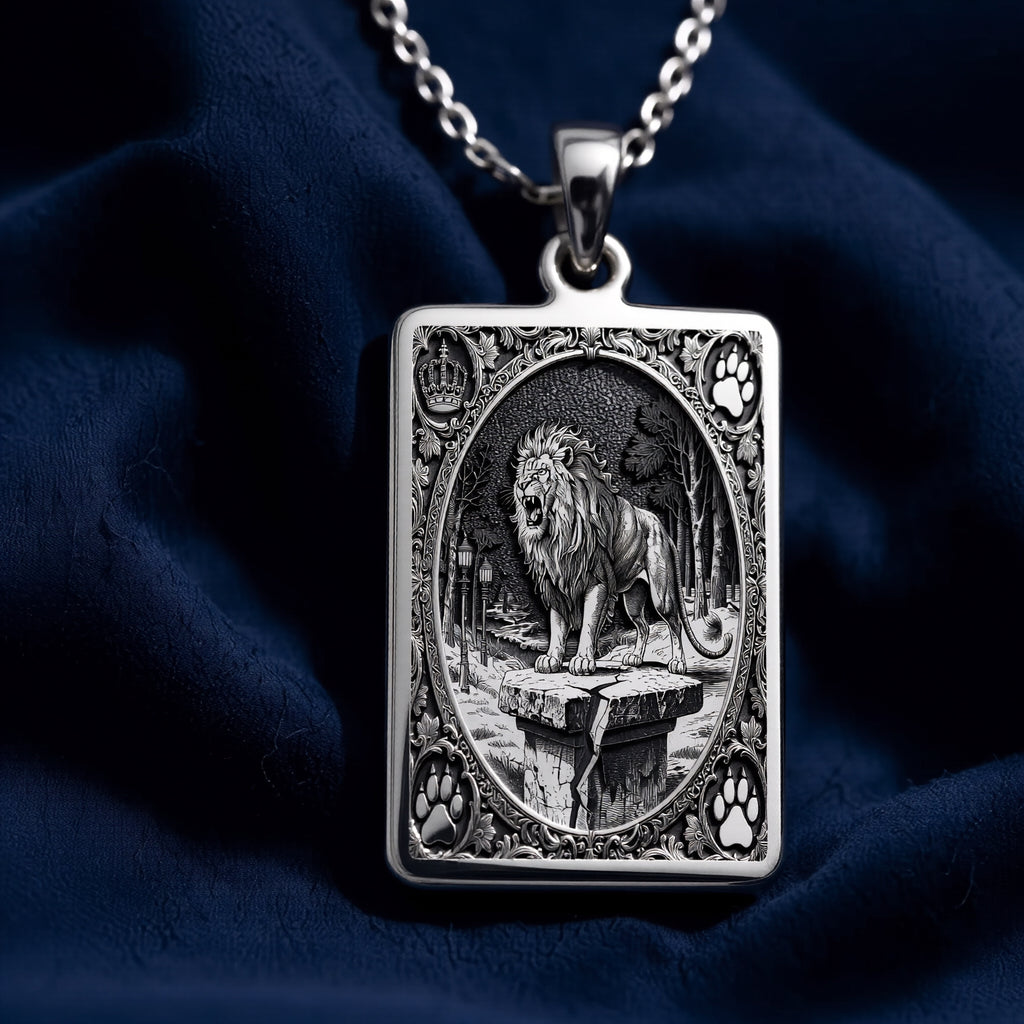 Silver pendant featuring a detailed design of a lion with a crown motif, shown from a straight-on view. The pendant has a polished surface finish and is attached to a chain.
