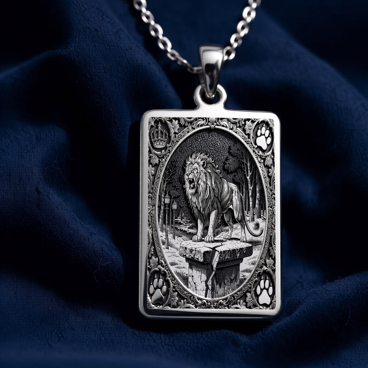 Silver pendant featuring a detailed design of a lion with a crown motif, shown from a straight-on view. The pendant has a polished surface finish and is attached to a chain.