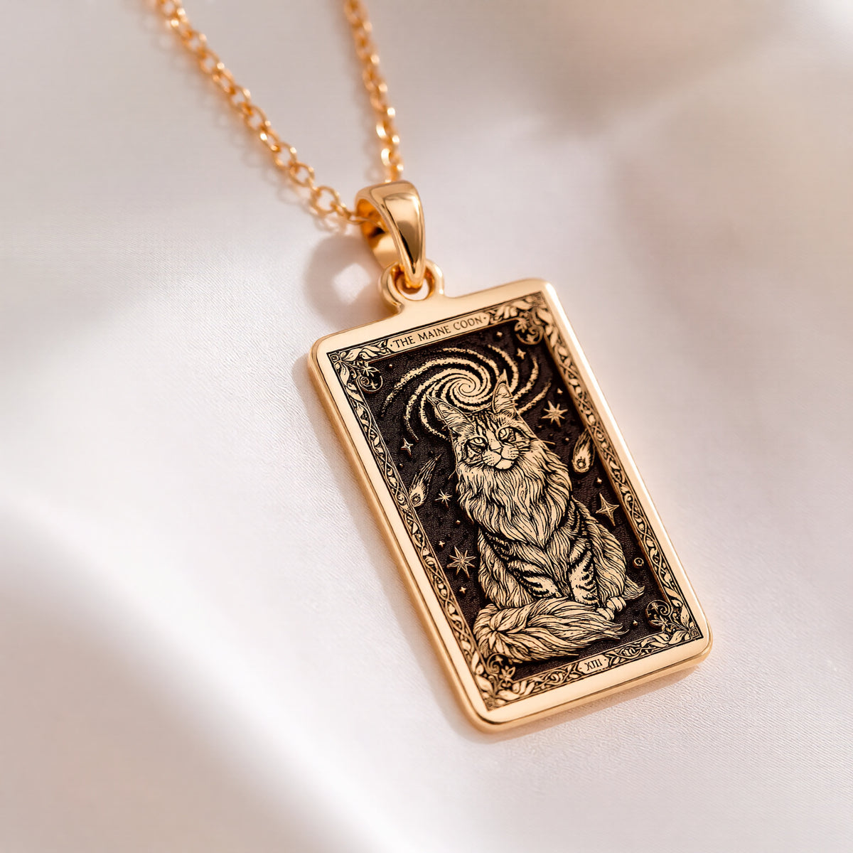 An heirloom-quality 14K solid gold Maine Coon tarot pendant. The art shows the majestic cat in a cosmic swirl, symbolizing its mystical nature, a precious cat mom gift.