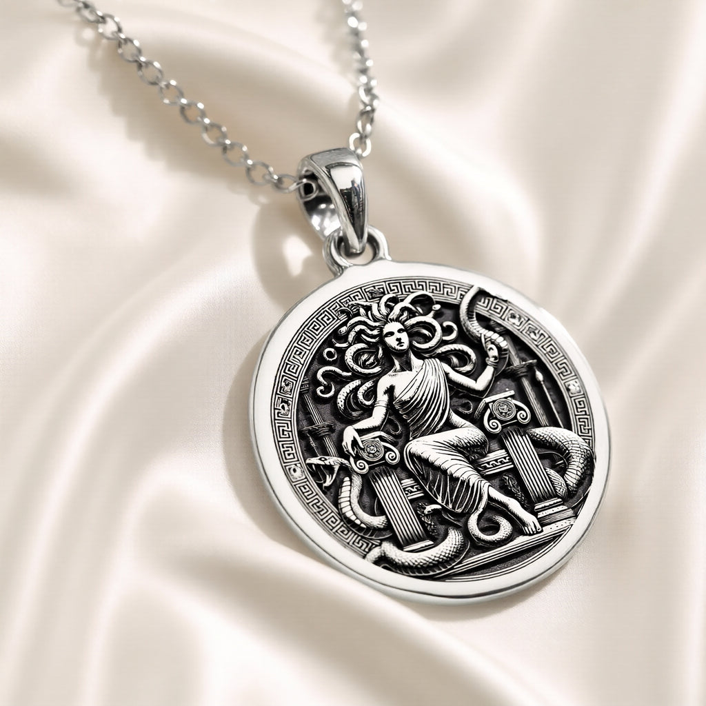 Silver pendant featuring a detailed Medusa Gorgon motif with an ancient mythological design. The image displays size charts for the pendant and chain lengths, showing measurements in both centimeters and inches.
