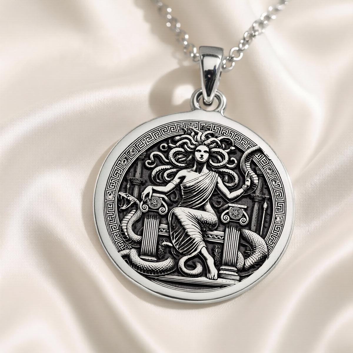 Silver pendant featuring a detailed Medusa Gorgon head design with intricate scales and hair texture. The pendant has a polished, reflective surface finish and is shown in a close-up view against a plain background.