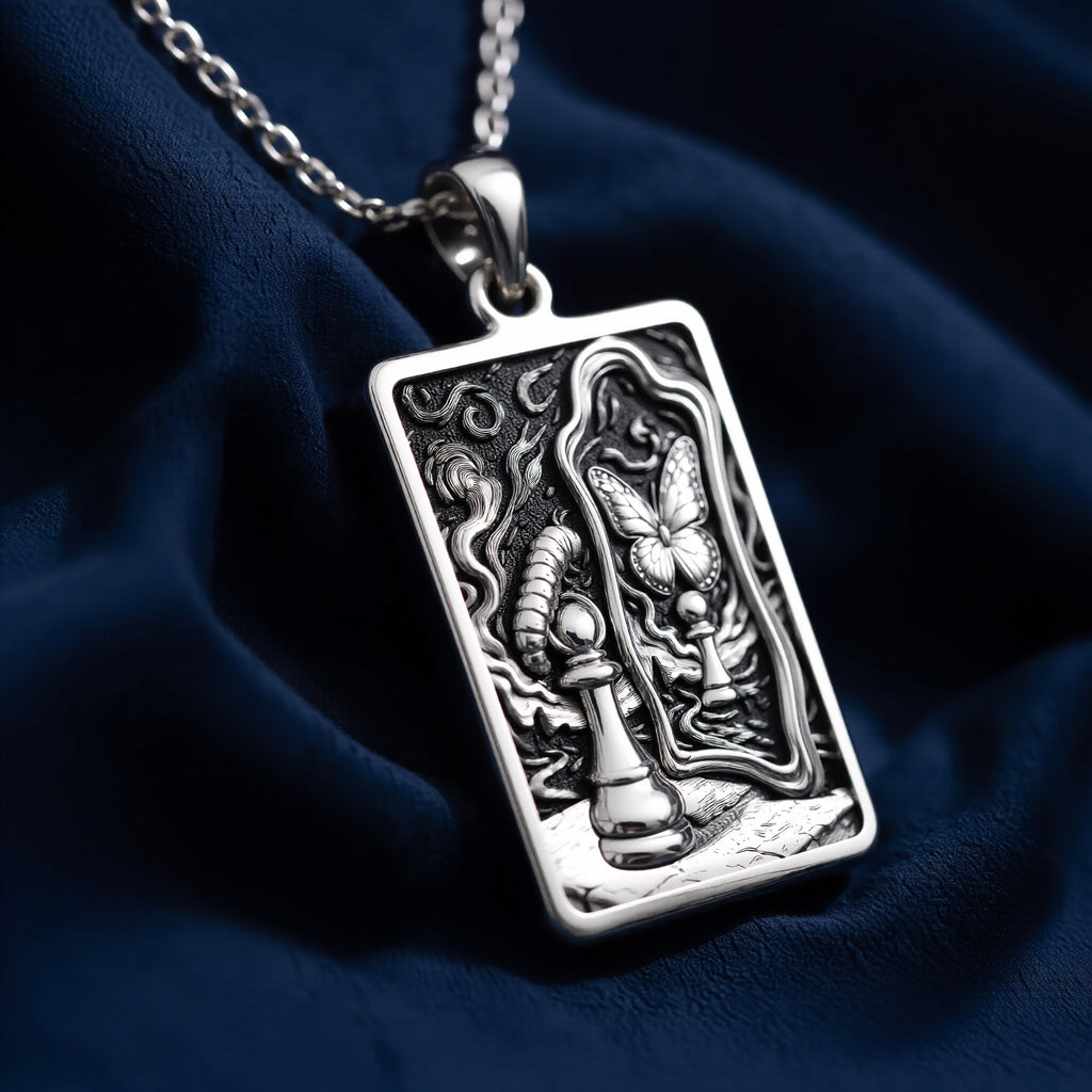 Silver necklace featuring a pendant with an abstract, flowing design inspired by metamorphosis and rebirth. The pendant has a polished finish and is shown from a slight angle, highlighting the detailed spiritual symbol art.