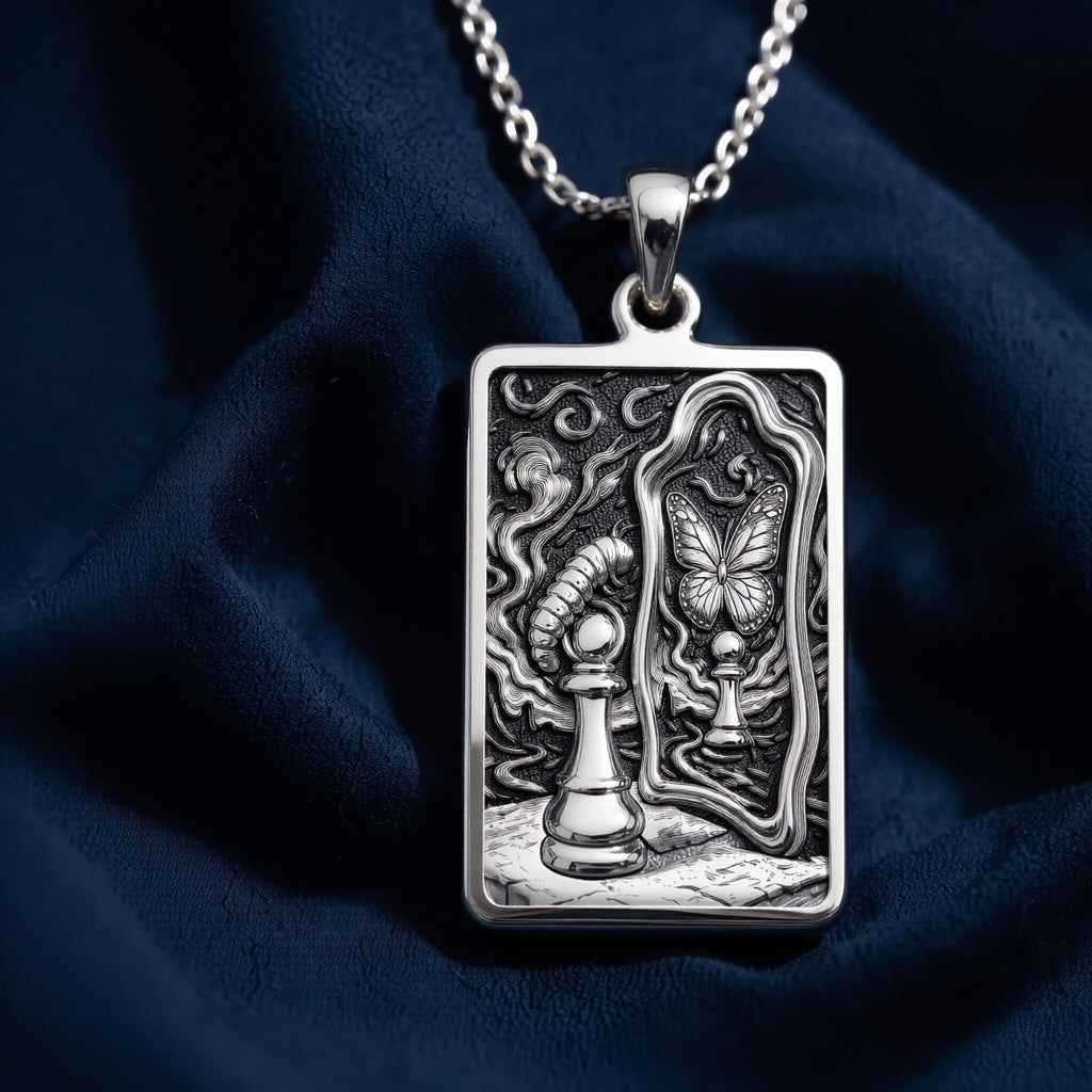 Silver toned rectangular pendant with detailed line art design. This necklace is displayed on black fabric alongside several faceted gemstones. - View 5