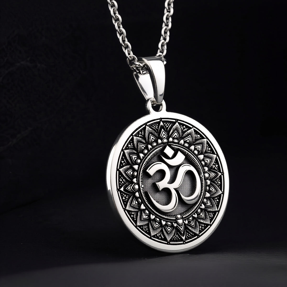 Silver circular pendant featuring an ornate border design around the central Om motif. The pendant is suspended from a silver chain, presented in a clear, frontal view. - View 2