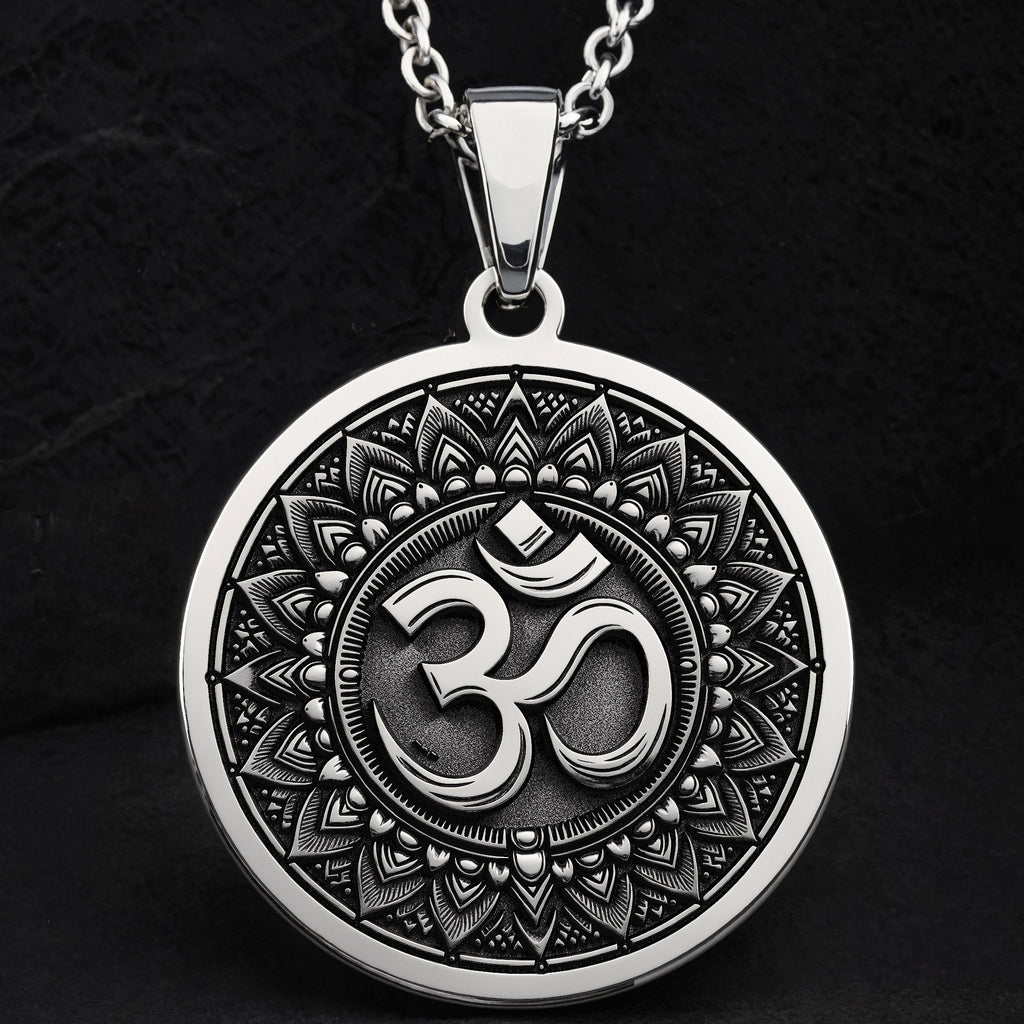 Silver circular pendant featuring an ornate border design around the central Om motif. The pendant is suspended from a silver chain, presented in a clear, frontal view.