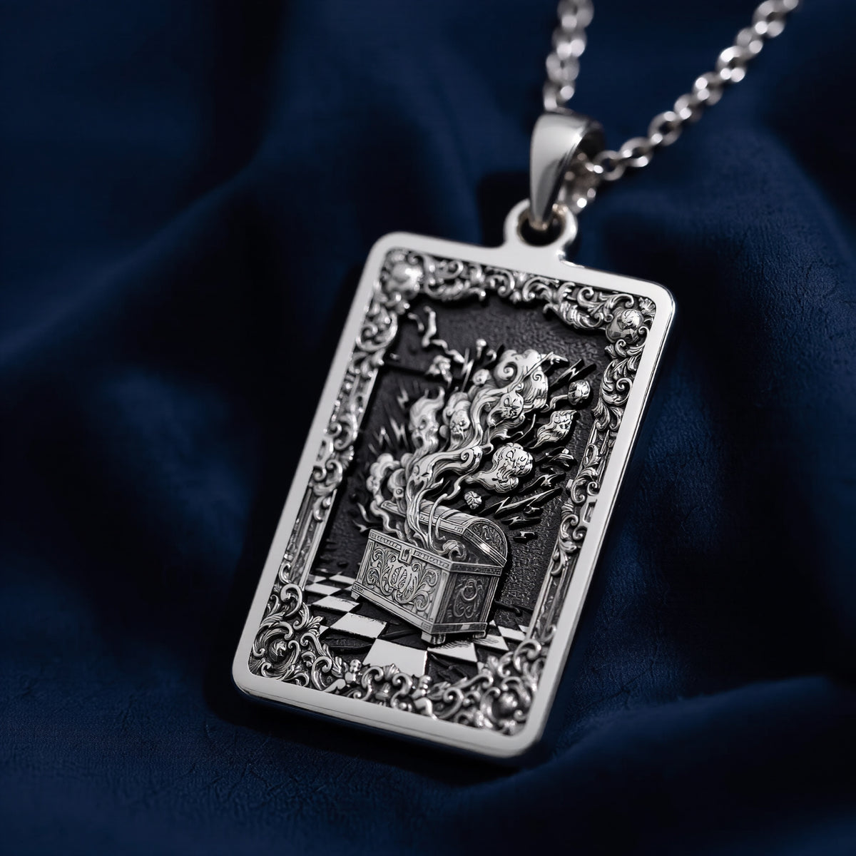 Silver rectangular pendant necklace featuring an ornate, detailed frame design with intricate scrollwork. The pendant is attached to a silver chain and displayed among faceted gemstones. - View 4