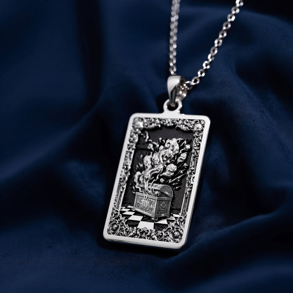 Silver rectangular pendant necklace featuring an ornate, detailed frame design with intricate scrollwork. The pendant is attached to a silver chain and displayed among faceted gemstones. - View 7