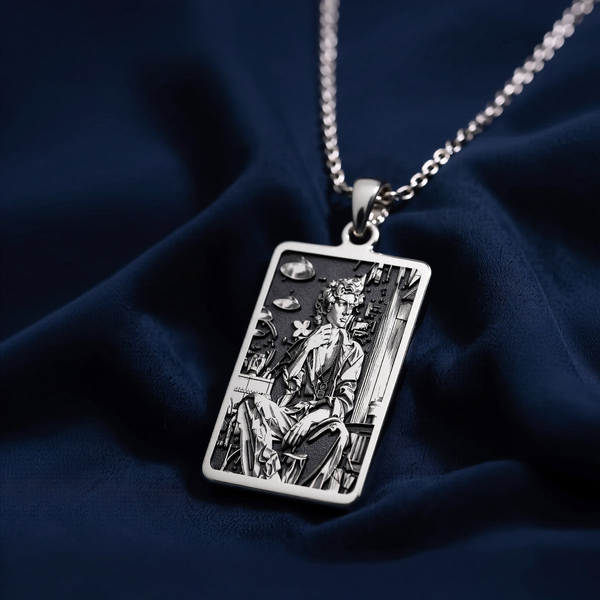 Silver rectangular pendant featuring an engraved classical design. This piece is suspended by a silver-toned chain and presented on a dark backdrop, emphasizing the detailed texture of the metal. - View 7