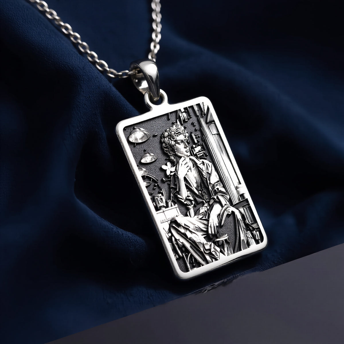 Silver rectangular pendant featuring an engraved classical design. This piece is suspended by a silver-toned chain and presented on a dark backdrop, emphasizing the detailed texture of the metal. - View 8