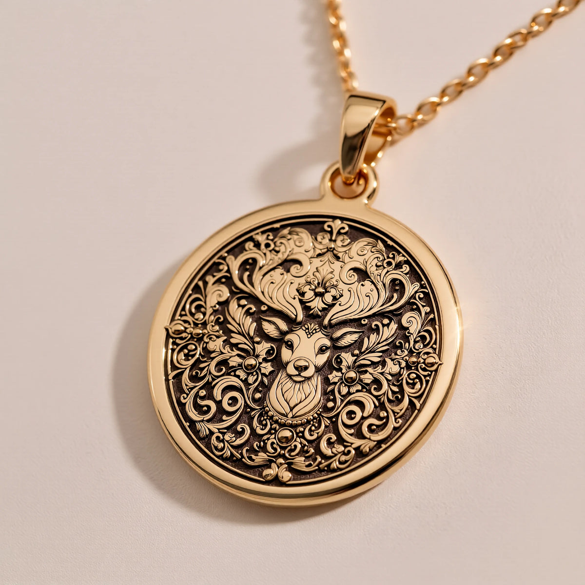 Gold plated pendant featuring an intricate stag deer forest lord design with detailed scrollwork and foliage. The pendant has an antique finish and is shown from a slightly elevated angle, hanging from a delicate gold chain.