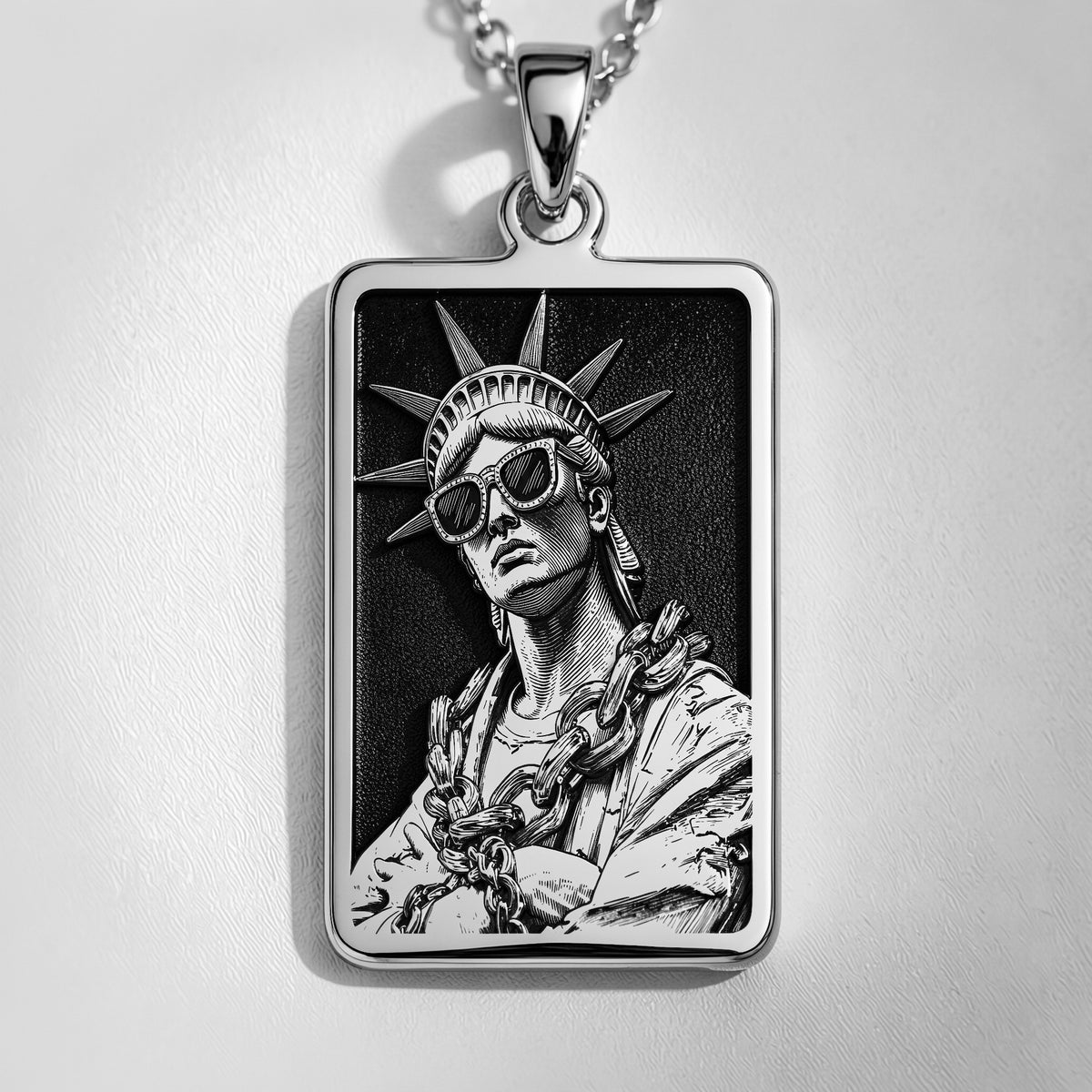 Silver plated rectangular pendant featuring a detailed classical figure with a crown motif and draped fabric. The pendant is attached to a silver chain and shown in an overhead view.