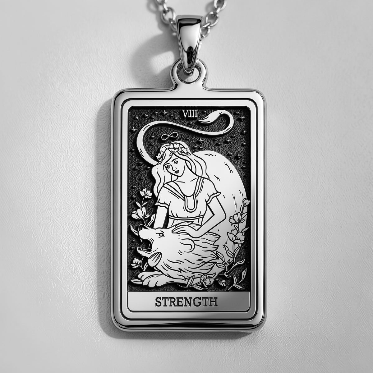 Silver pendant necklace featuring a rectangular design of the Strength Tarot Arcana card with intricate line art. The pendant has a polished finish and is attached to a silver chain.